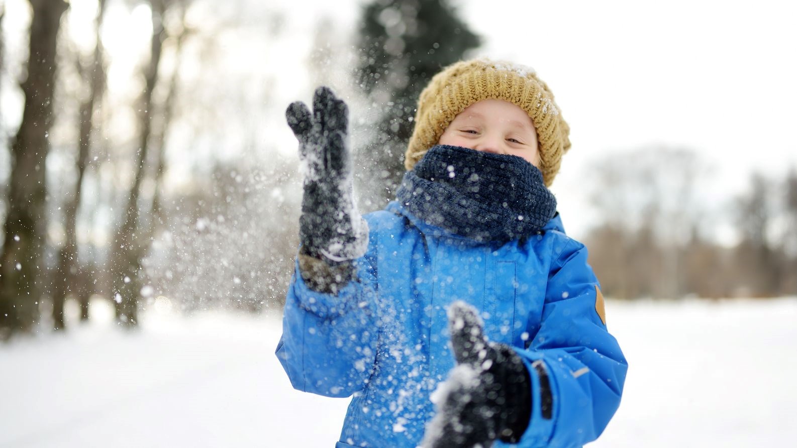 Boy happily playing in the snow.